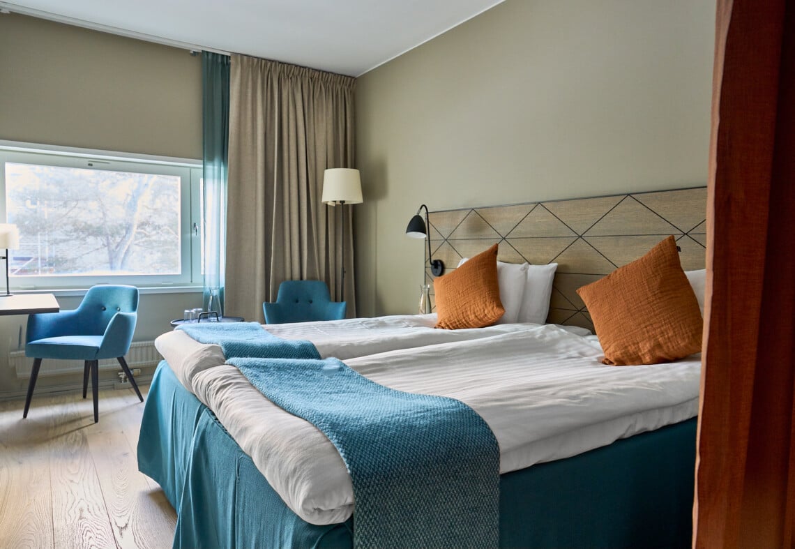 Dubbelsäng med fin bäddning i dubbelrum Harmoni. Lyxig sänggavel i fint träslag.