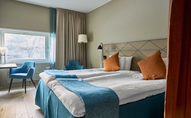 Dubbelsäng med fin bäddning i dubbelrum Harmoni. Lyxig sänggavel i fint träslag.