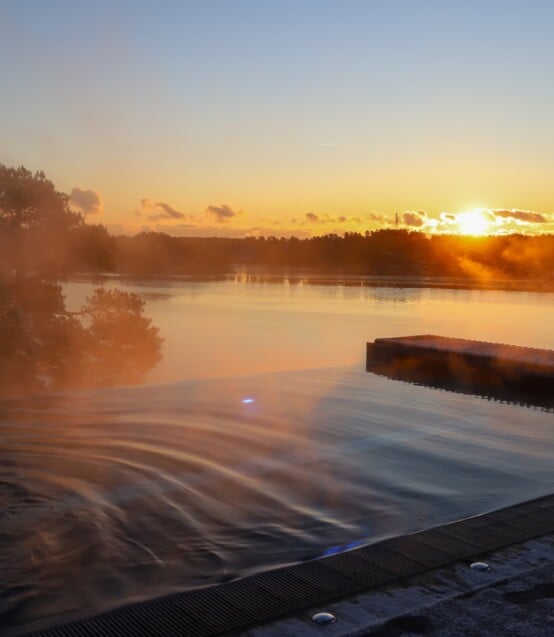 Solnedgång över infinitypoolen i skärgården. Havsutsikt.