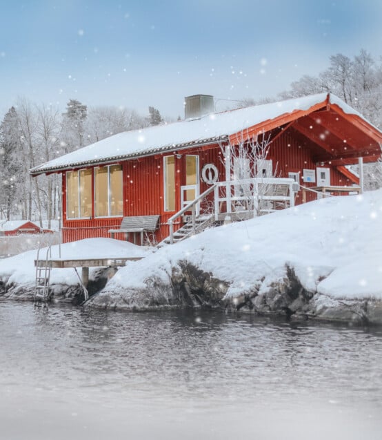 Vedeldad bastu i skärgården. Snön faller i skärgården.