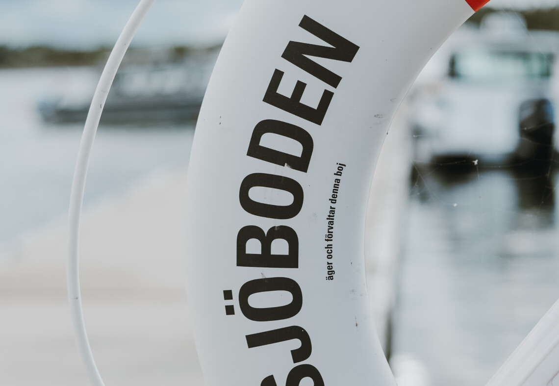 En boj i rött och vitt. skärgård och sommar. Sjöboden skärgårdskrog. Middag i skärgårdsmiljö intill havet. Mat och dryck i skärgårdsmiljö.