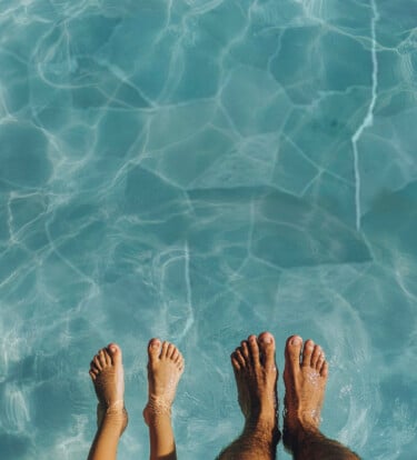 barn- och vuxenfötter i varm pool